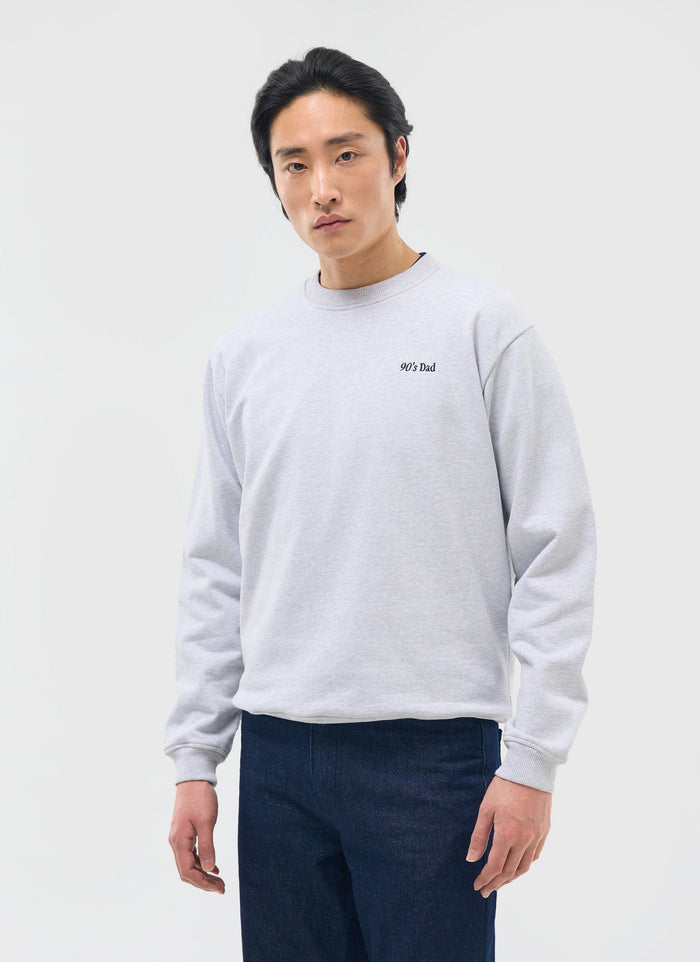 A male model wears the 90's Dad Sweatshirt in Athletic Grey from Percival against a white studio background.