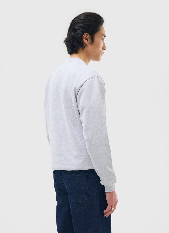 A model seen from the back wearing the Percival 90's Dad Sweatshirt in Athletic Grey with dark denim jeans.