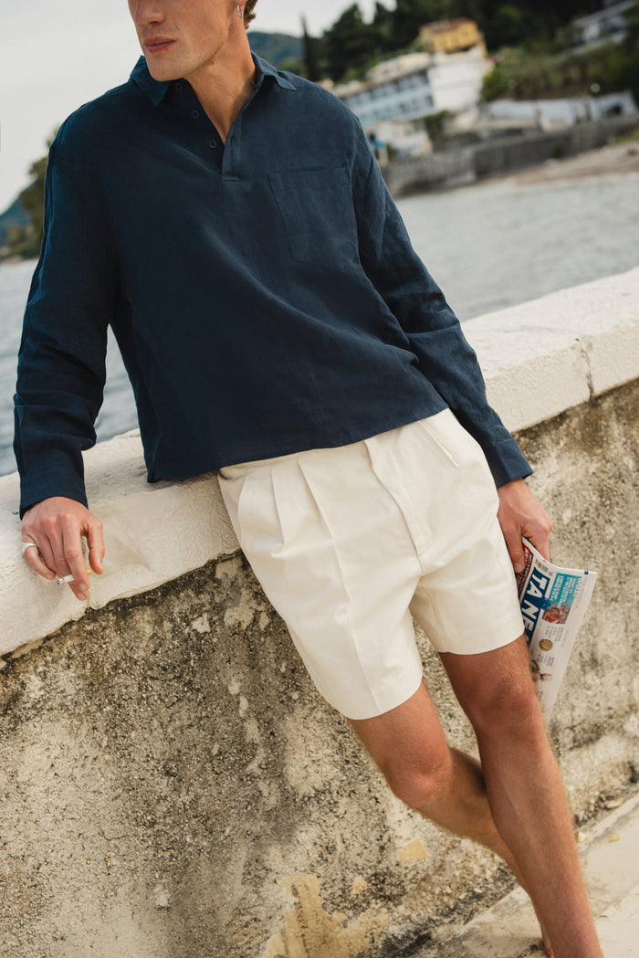 Navy Percival Alec Pullover Shirt in 100% linen, featuring a boxy cropped fit and half-placket, worn by the coast.