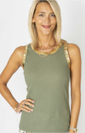 Woman wearing a green tank top with gold trim on a white background