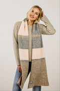 Woman wearing a long, patterned scarf with a neutral background