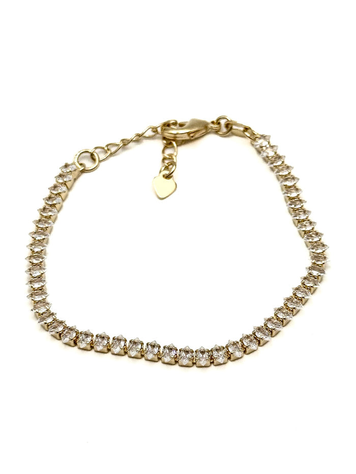 Ariana gold-tone crystal tennis bracelet with clear stones, extender chain, and small heart charm arranged in a circle on a white background