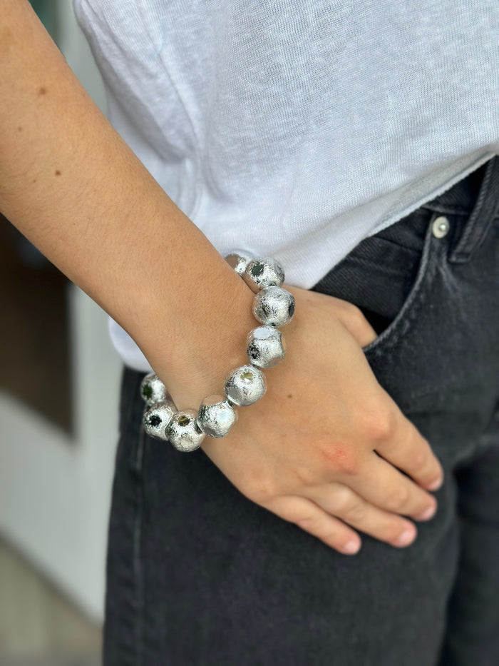 Person wearing a silver beaded bracelet
