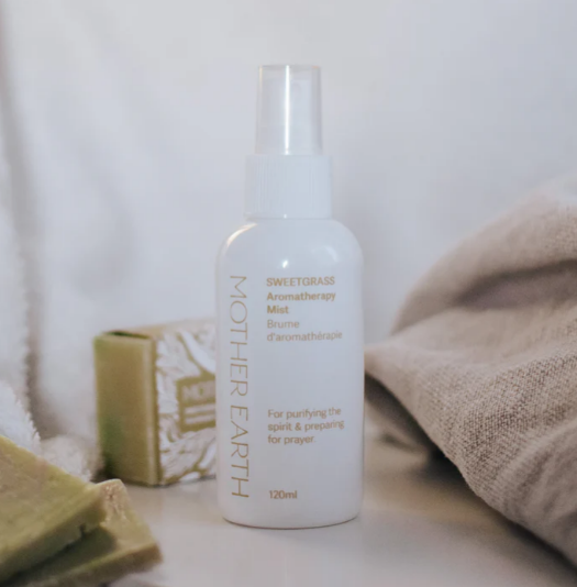 White bottle of 'Sweetgrass Aromatherapy Mist' by Mother Earth on a neutral background