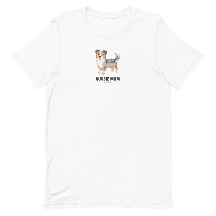 The Sassy Woof Aussie Mom Tee is a white unisex shirt made from eco-friendly cotton with an Australian Shepherd dog drawing and bold "AUSSIE MOM" text on the chest.