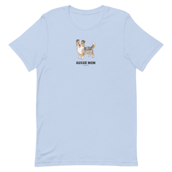 The Aussie Mom Tee by Sassy Woof is a light blue, eco-friendly cotton unisex shirt featuring a centered Australian Shepherd illustration and bold black lettering—a perfect pick for proud dog lovers.