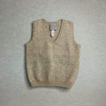 Brown knitted baby vest with a label on a gray background