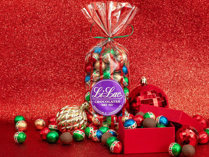 A clear bag filled with colorful chocolate balls in assorted foil colors
