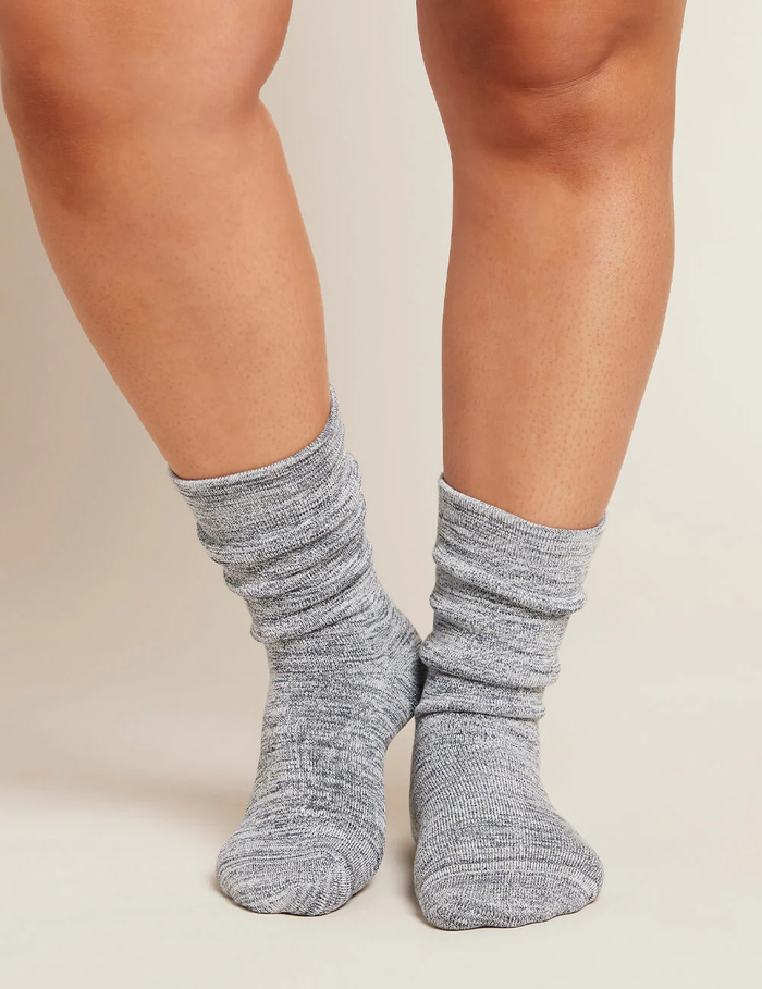 Gray socks worn by a person on a neutral background