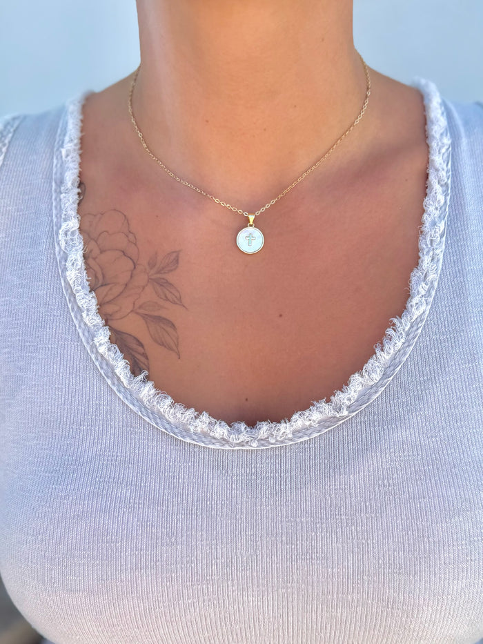 Gold filled mother of pearl cross pendant necklace being worn.