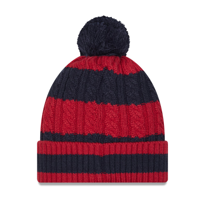 Rear view of the winter knit beanie, showcasing a clean and uniform design. The horizontal alternating stripes of dark navy blue and deep red wrap seamlessly around the entire cable-knit crown and the matching ribbed, fold-over cuff. The solid navy blue pom-pom sits perfectly centered on the peak of the hat