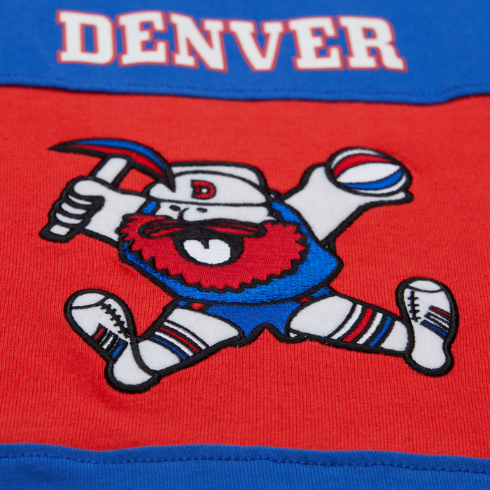 Up close view, a red chest stripe with a retro miner mascot logo and white 'DENVER NUGGETS' text