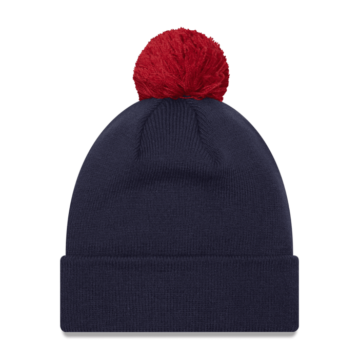 Back view of a dark navy blue knit beanie, showing the smooth, solid navy knit texture and a red pom-pom at the peak.
