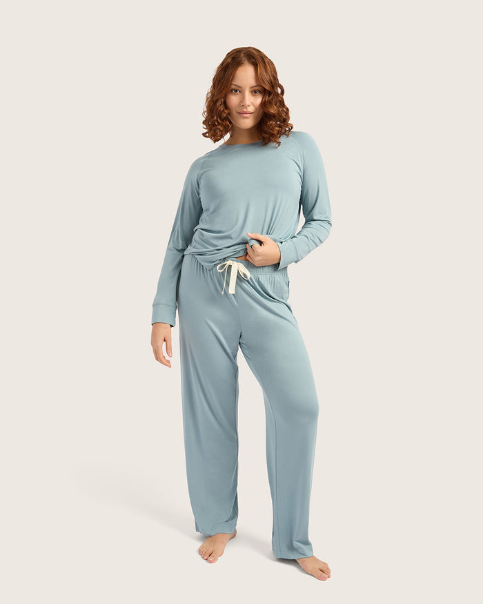 Woman wearing a light blue pajama set on a white background