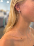 Grace Cross Studs in silver with baguette-style crystals on models ear