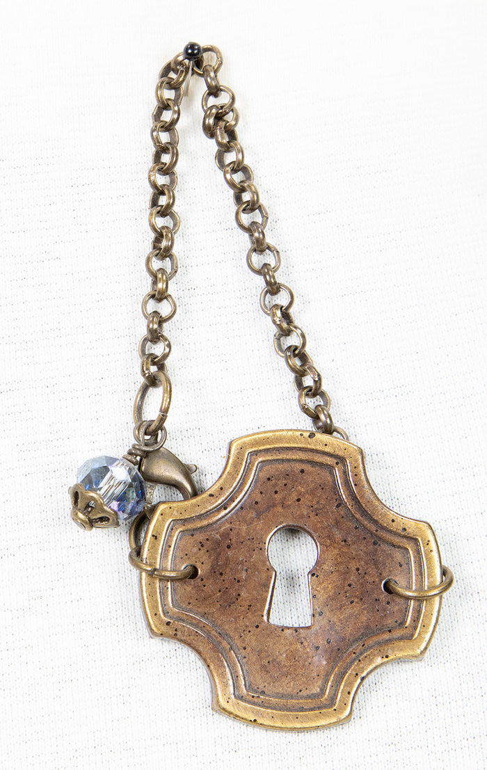 Bracelet featuring key plate and crystal charm