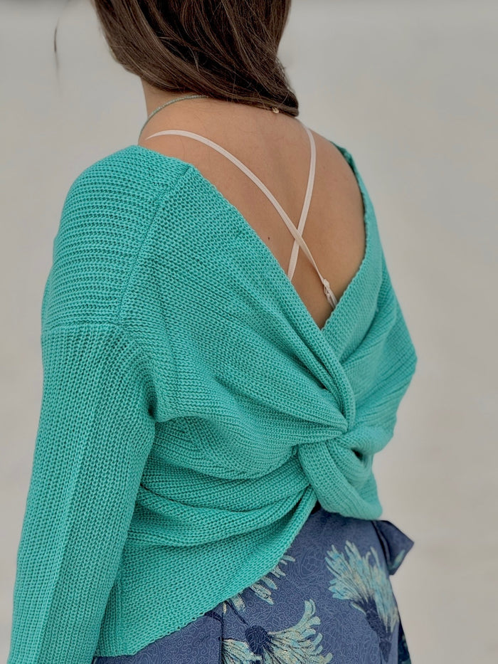 Model wearing Lily Sweater in Aqua with twist open back detail shown styled with a criss cross strap bralette