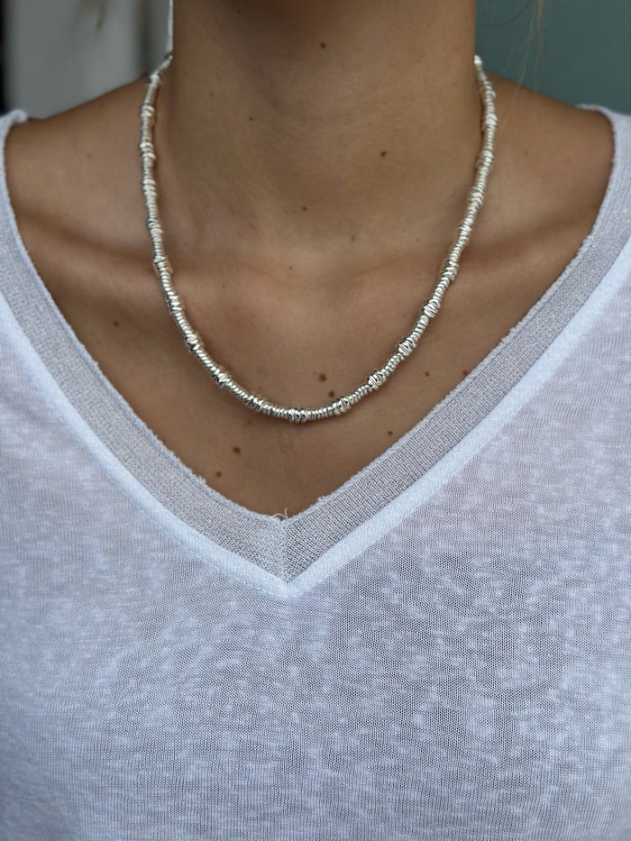 Necklace worn by a person wearing a white shirt