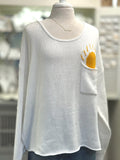 Cream open-knit scoop neck sweater with Sun design poking out of front chest pocket from Ardor Boutique