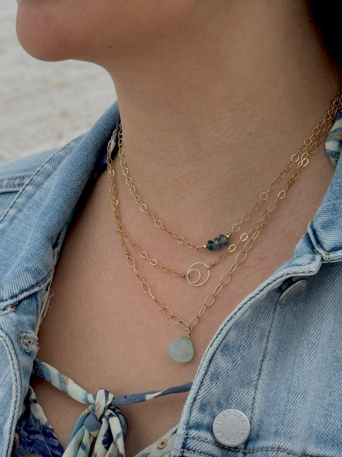 Close-up of a person wearing layered gold necklaces using the Gold Filled Magnetic Layering Clasp