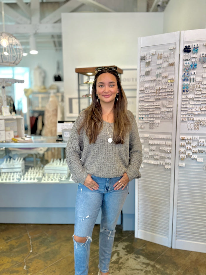 Woman standing in a store with jewelry display cases in the background