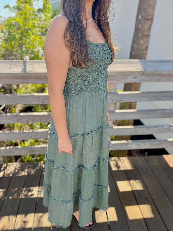 Woman wearing a green dress on a wooden deck