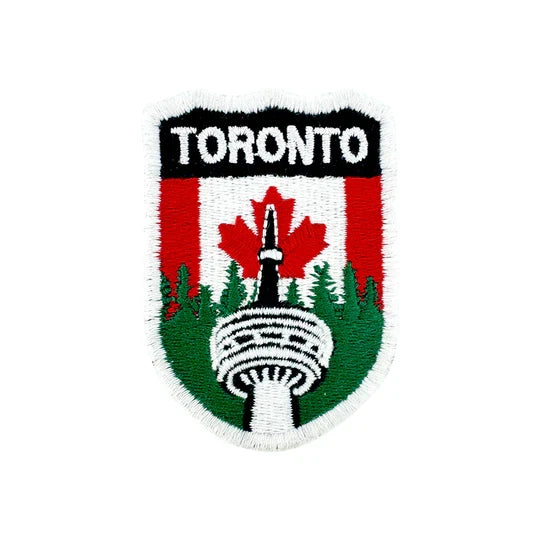 Embroidered patch with 'Toronto' text and a design of the CN tower and trees on a red and green background.