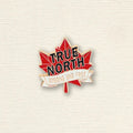 Maple leaf pin with 'True North Strong and Free' text on a textured beige background
