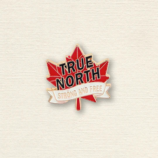 Maple leaf pin with 'True North Strong and Free' text on a textured beige background