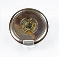 Close up shot of compass cover with engraved image of ship encircled by the words: "Marine Compass War of 1812"